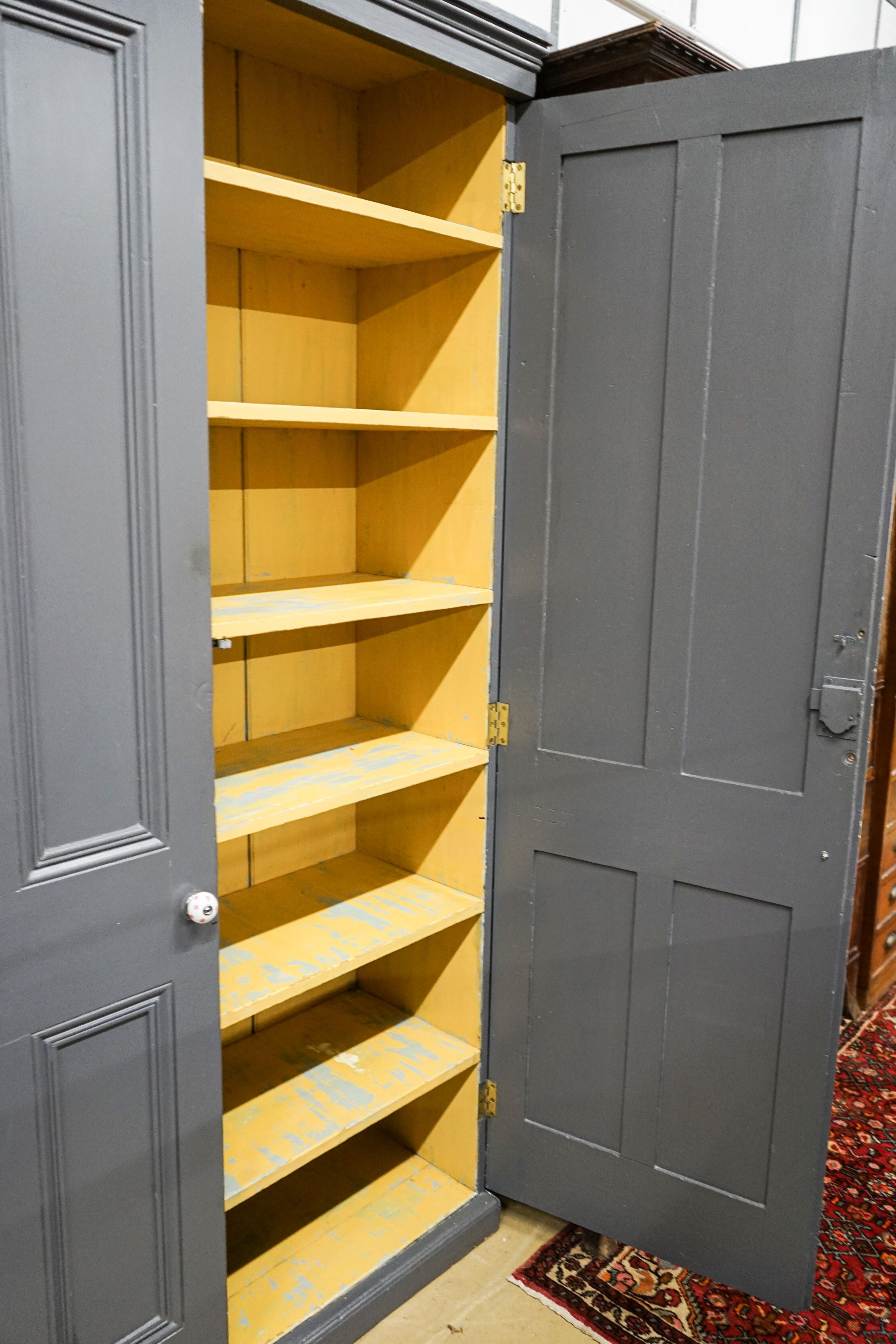 A Victorian painted panelled pine two door housekeeper's cupboard, width 130cm, depth 40cm, height 214cm